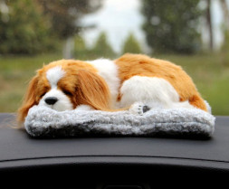 Собака на торпеду лежащая на коврике коричнево-белая